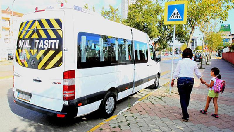 Okul Taşıtı beyaz servis minibüsü ve okula yürüyen öğrenci